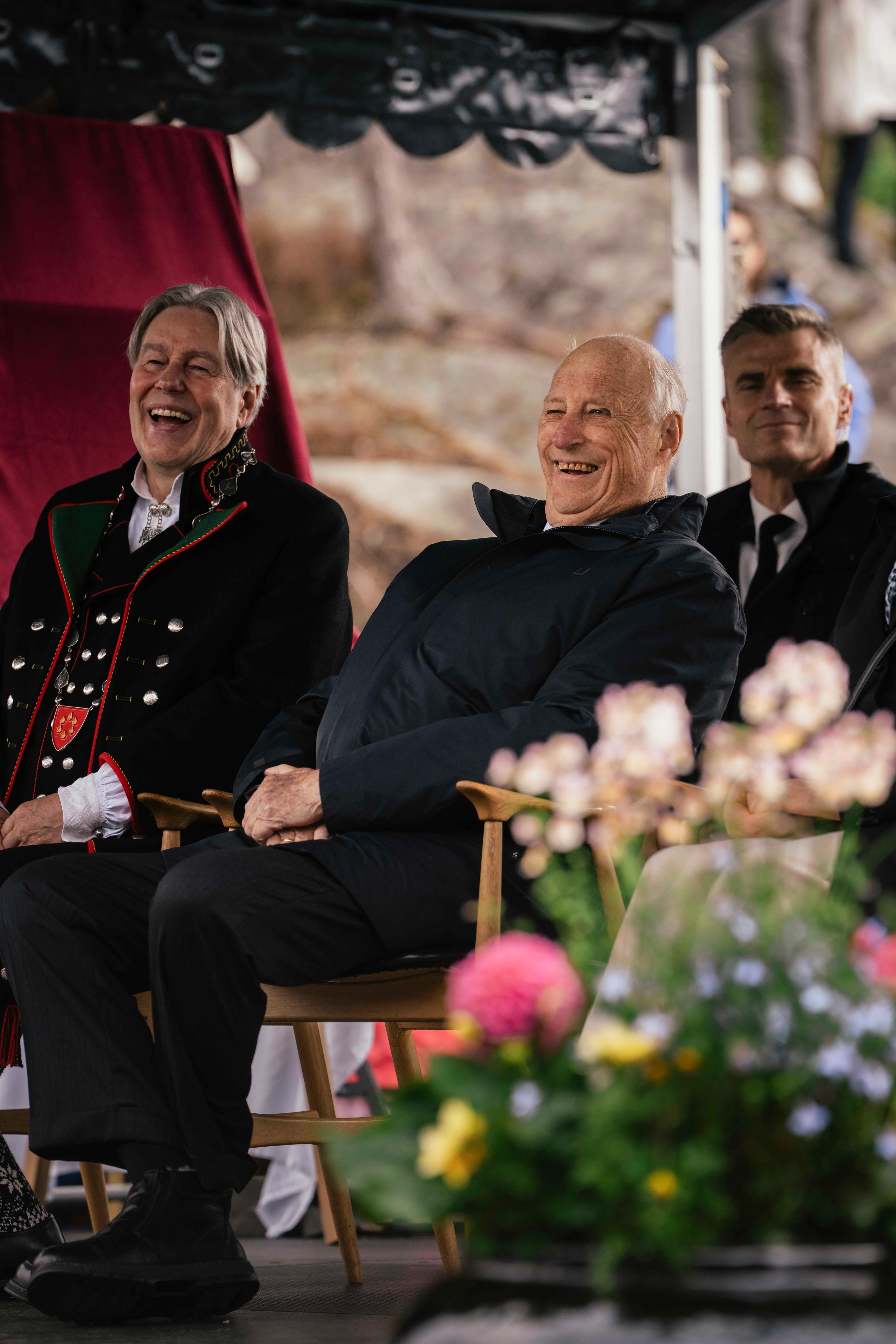 Kong Harald og ordføraren ler av underhaldninga.