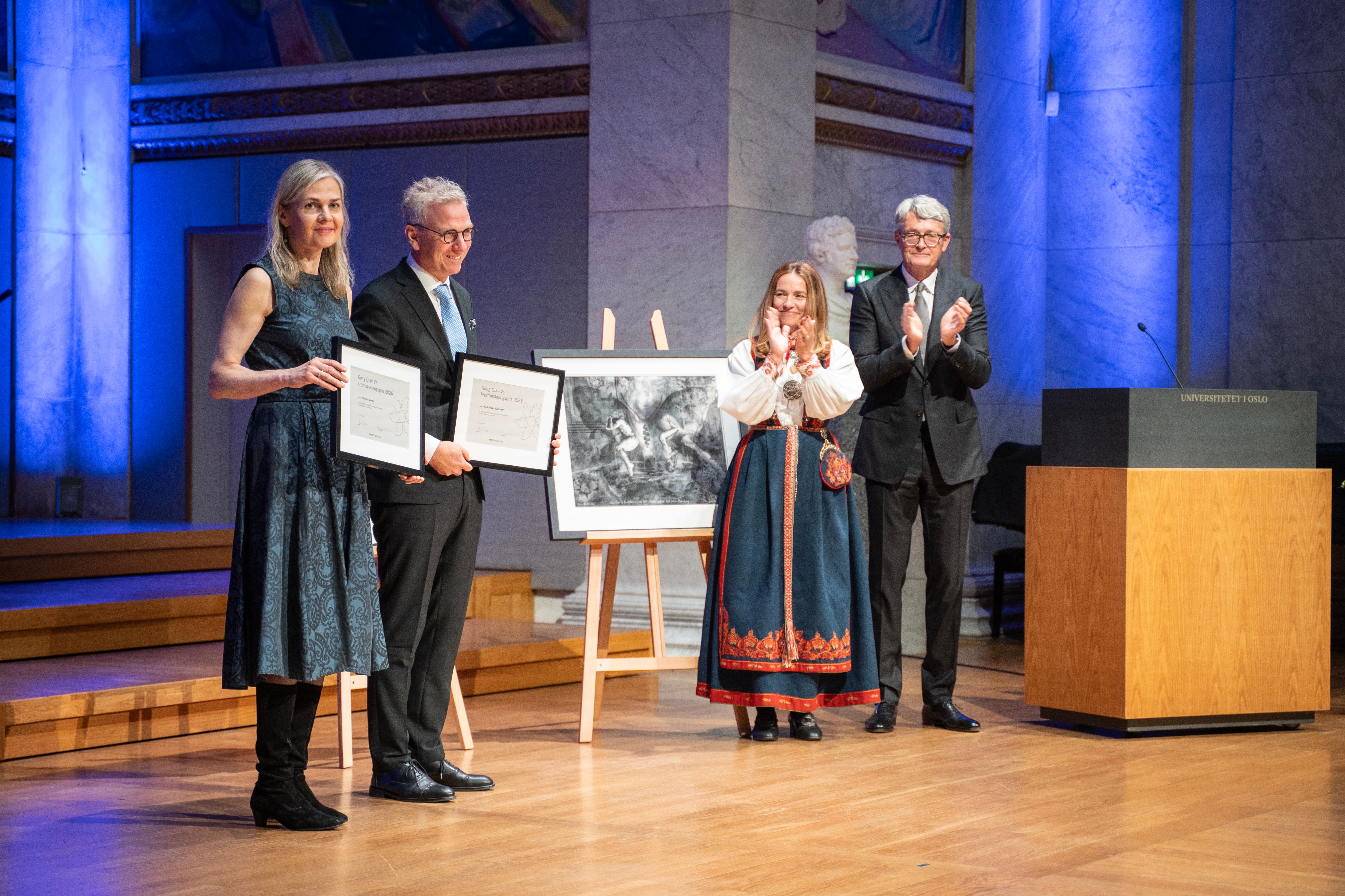 Prisvinnerne på scenen med hvert sitt innrammede diplom i hendene. Mottar applaus.