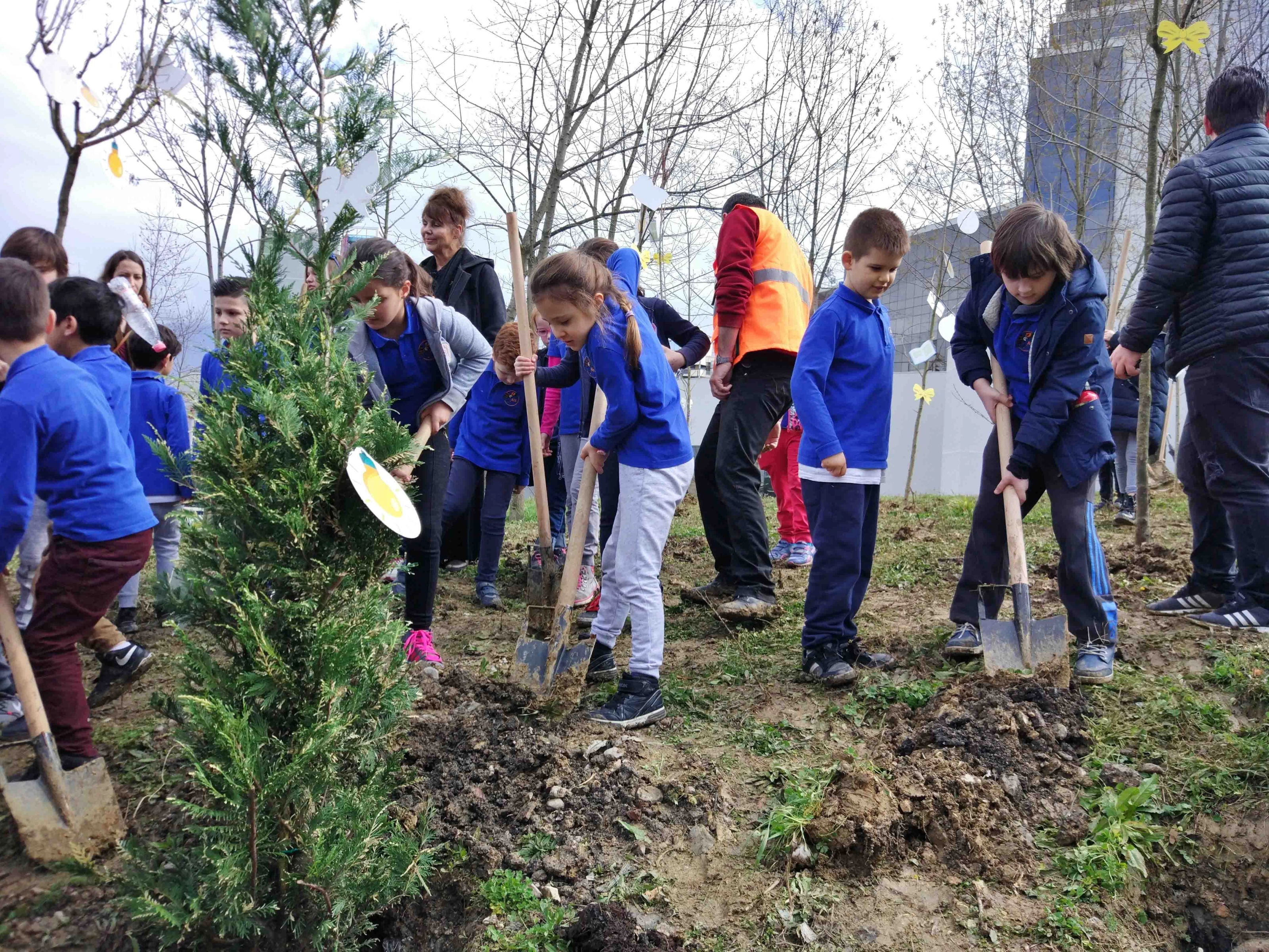 Children in blue school uniforms digging and gardening.