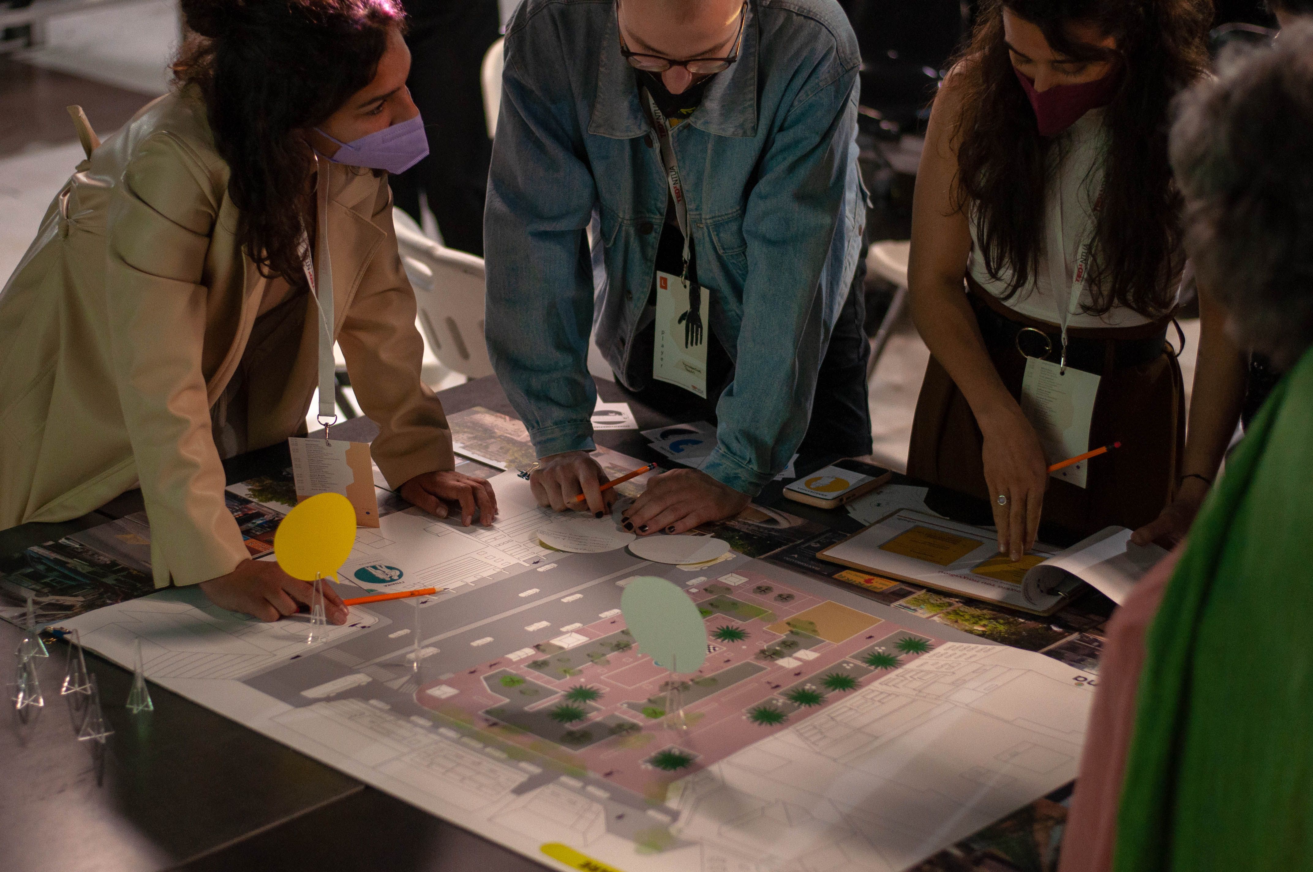 Four people stand over a plan.
