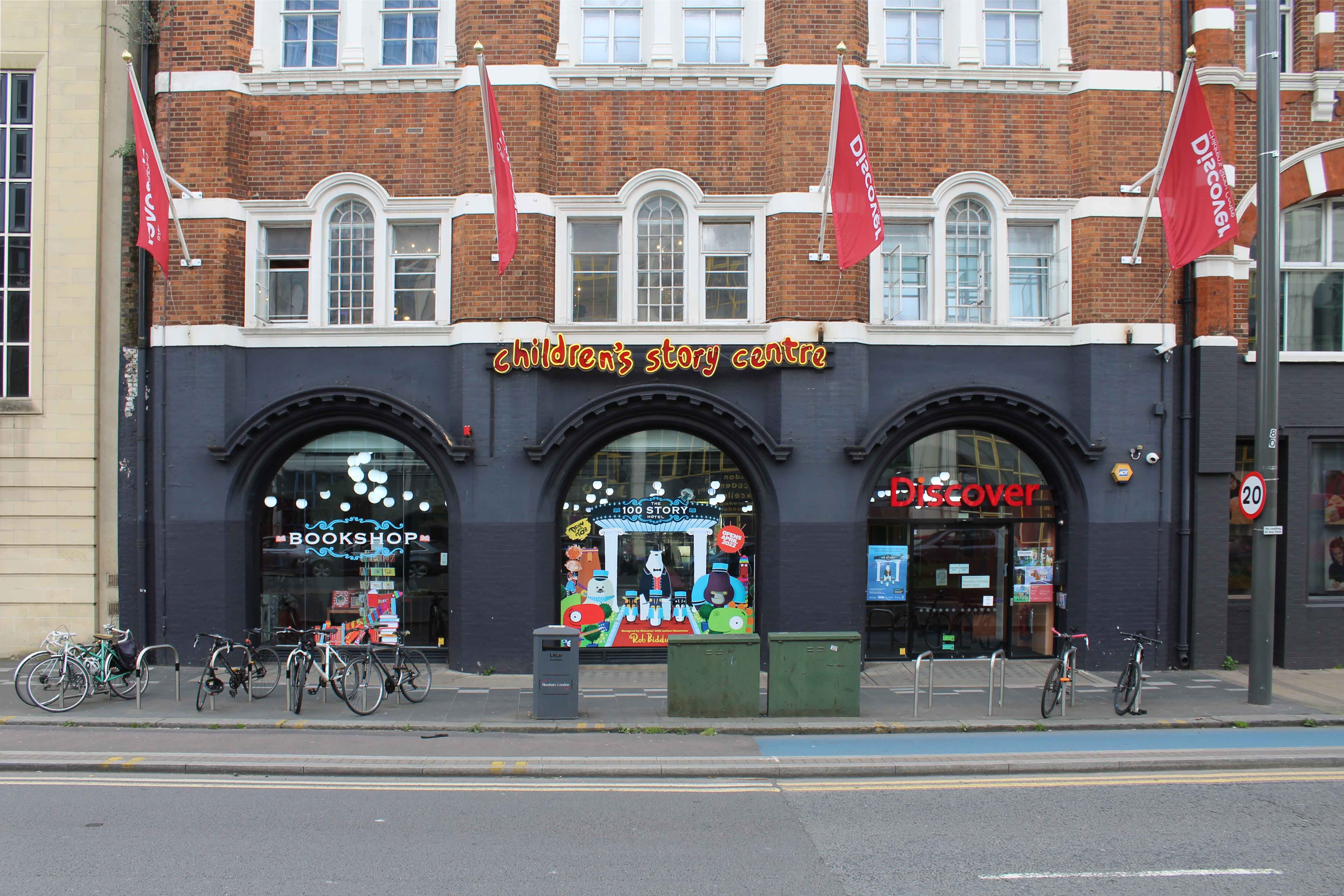 The façade to the Children's Story Centre with three arched display windows and cycle parking in front of the building.