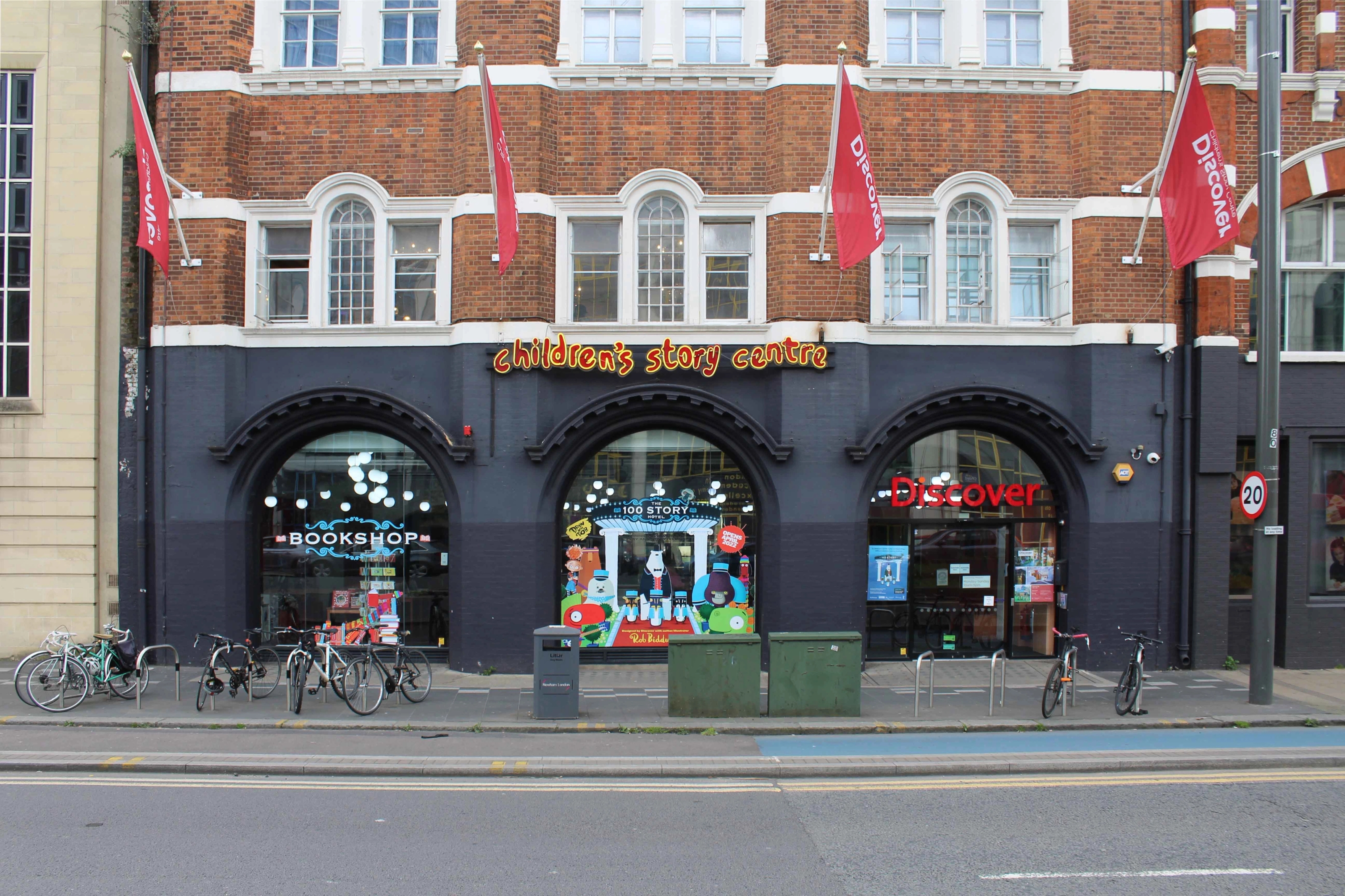 The façade to the Children's Story Centre with three arched display windows and cycle parking in front of the building.