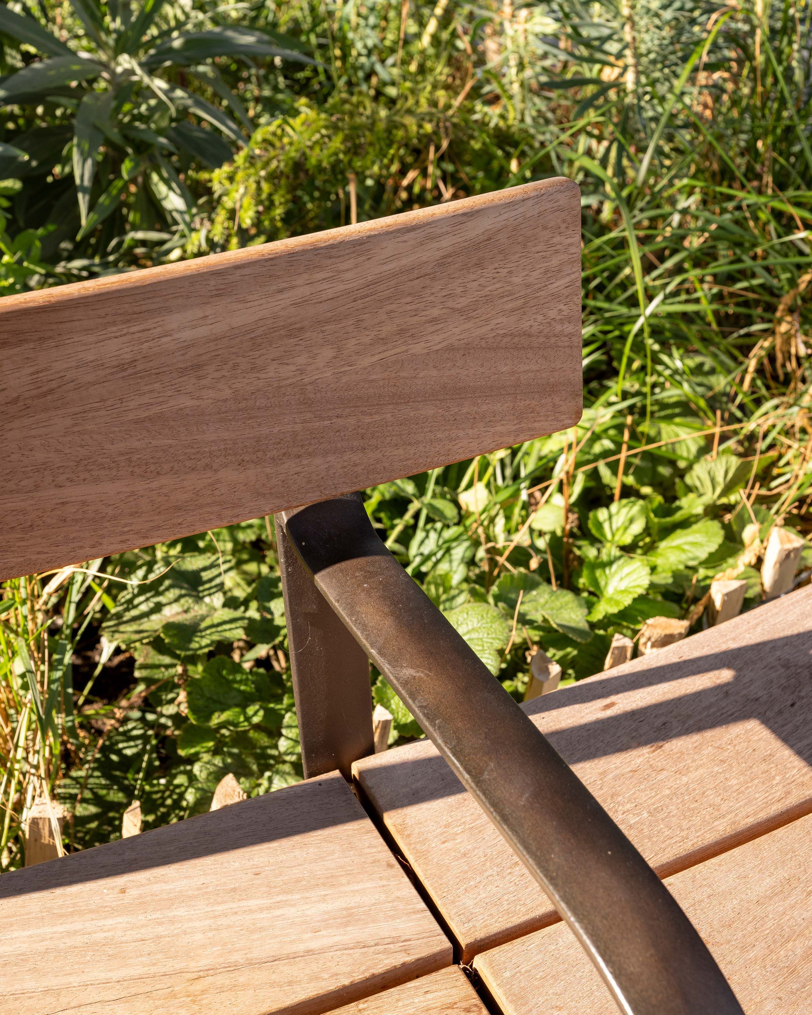 Close up of a the arm rest of wooden bench.