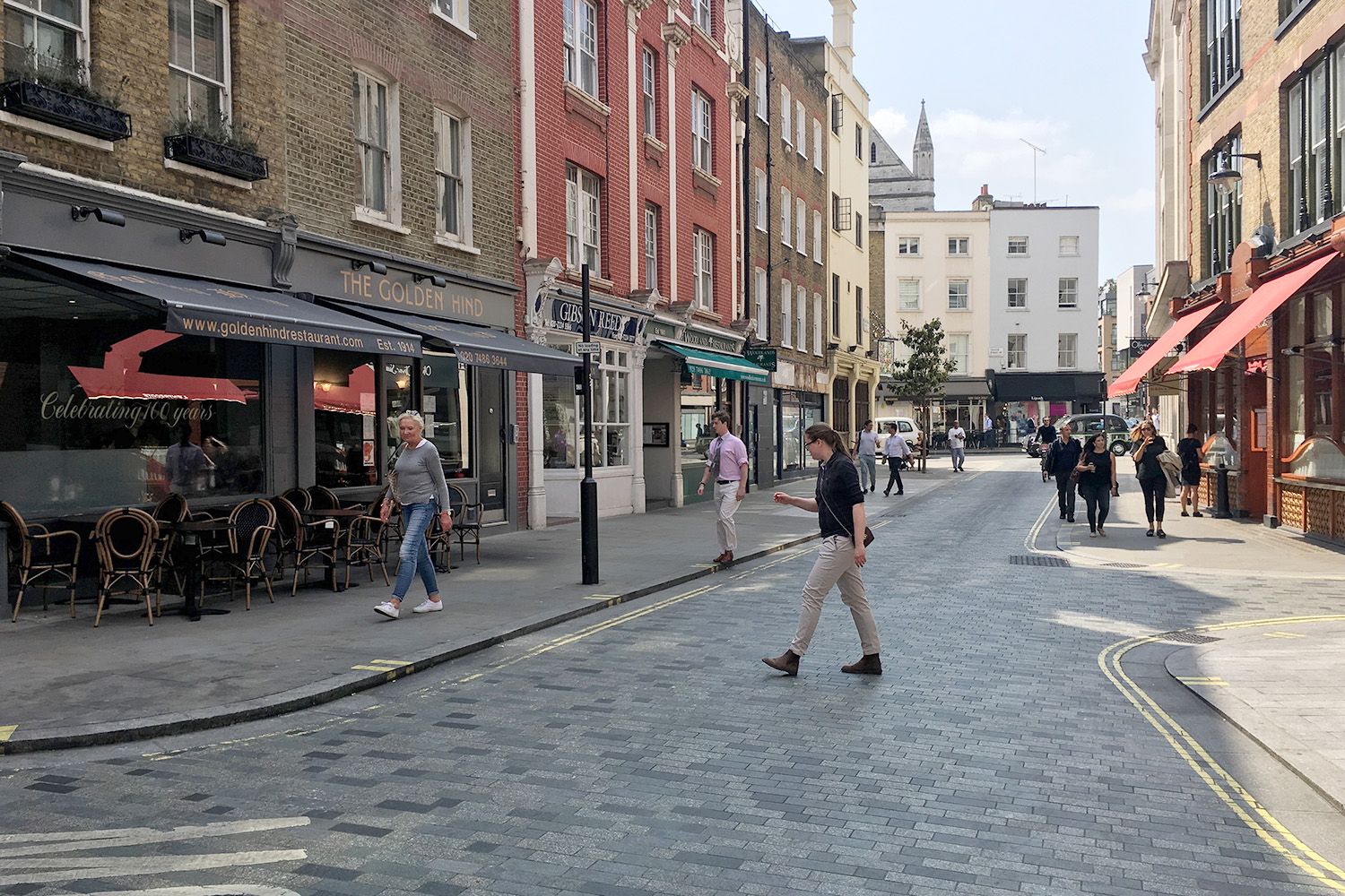 View of the completed Marylebone Lane design with pedestrian crossing the street.