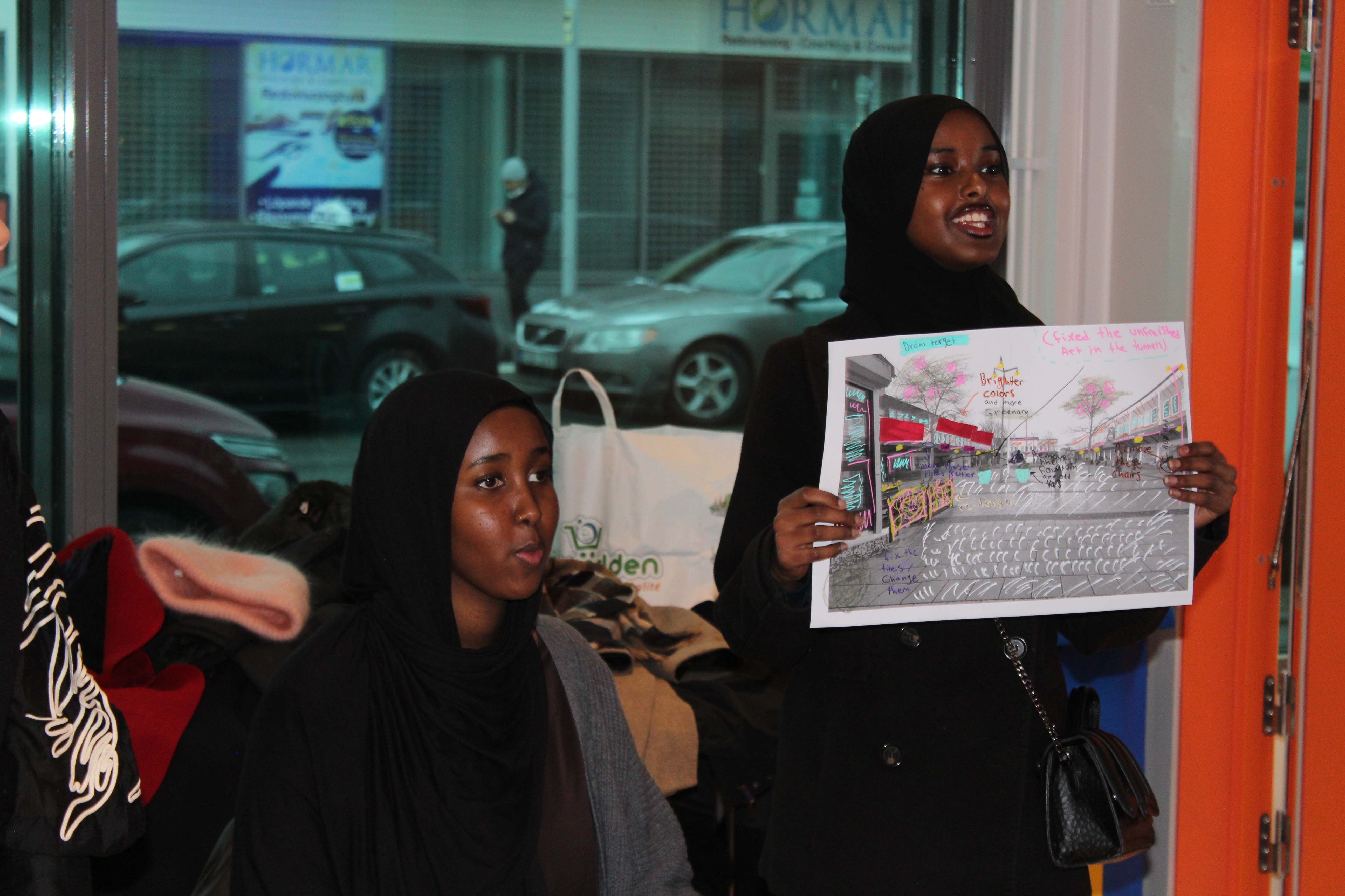 Two young people presenting a collage.