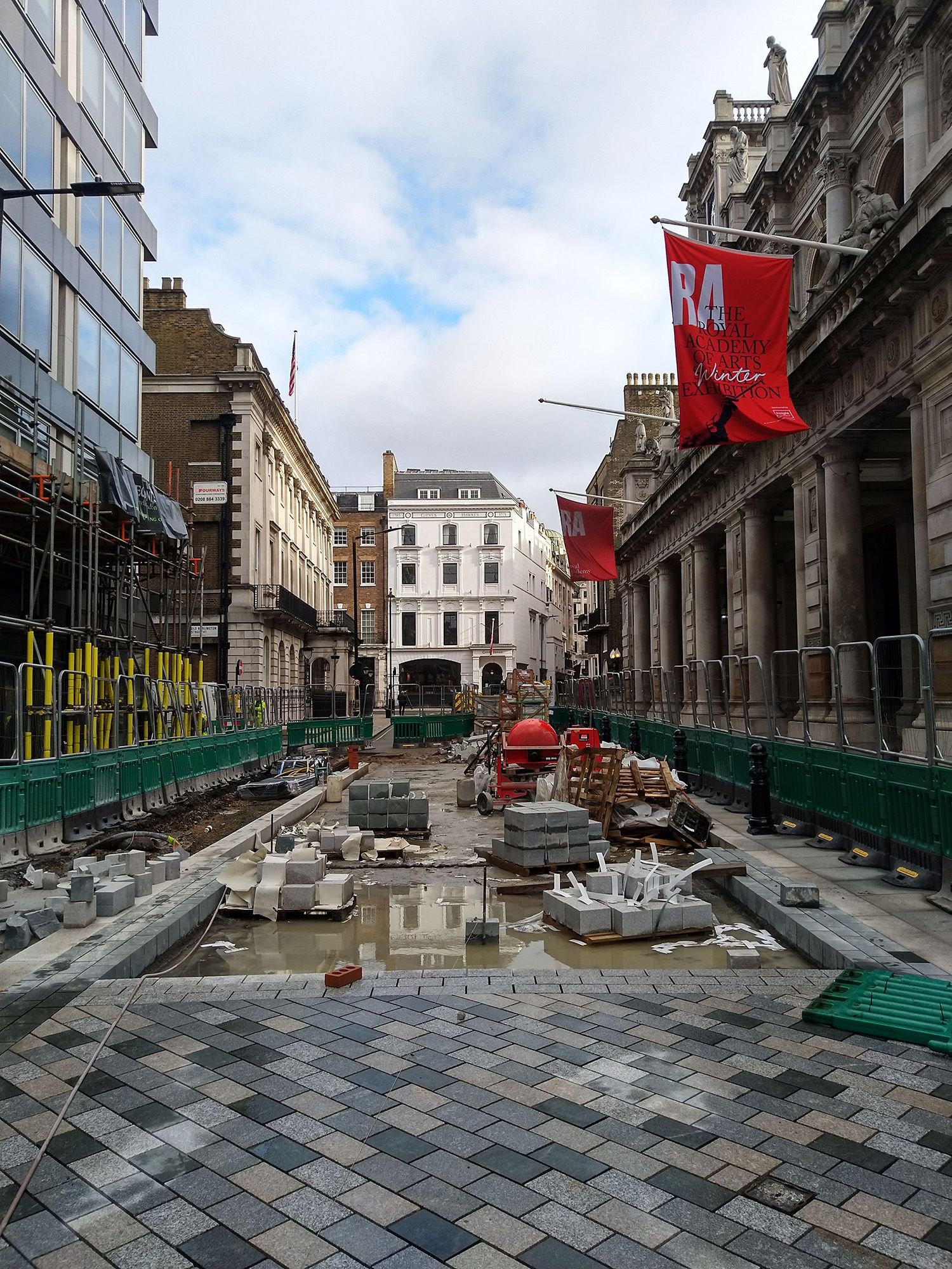 Construction site with bricks being laid down on an outside pathway.