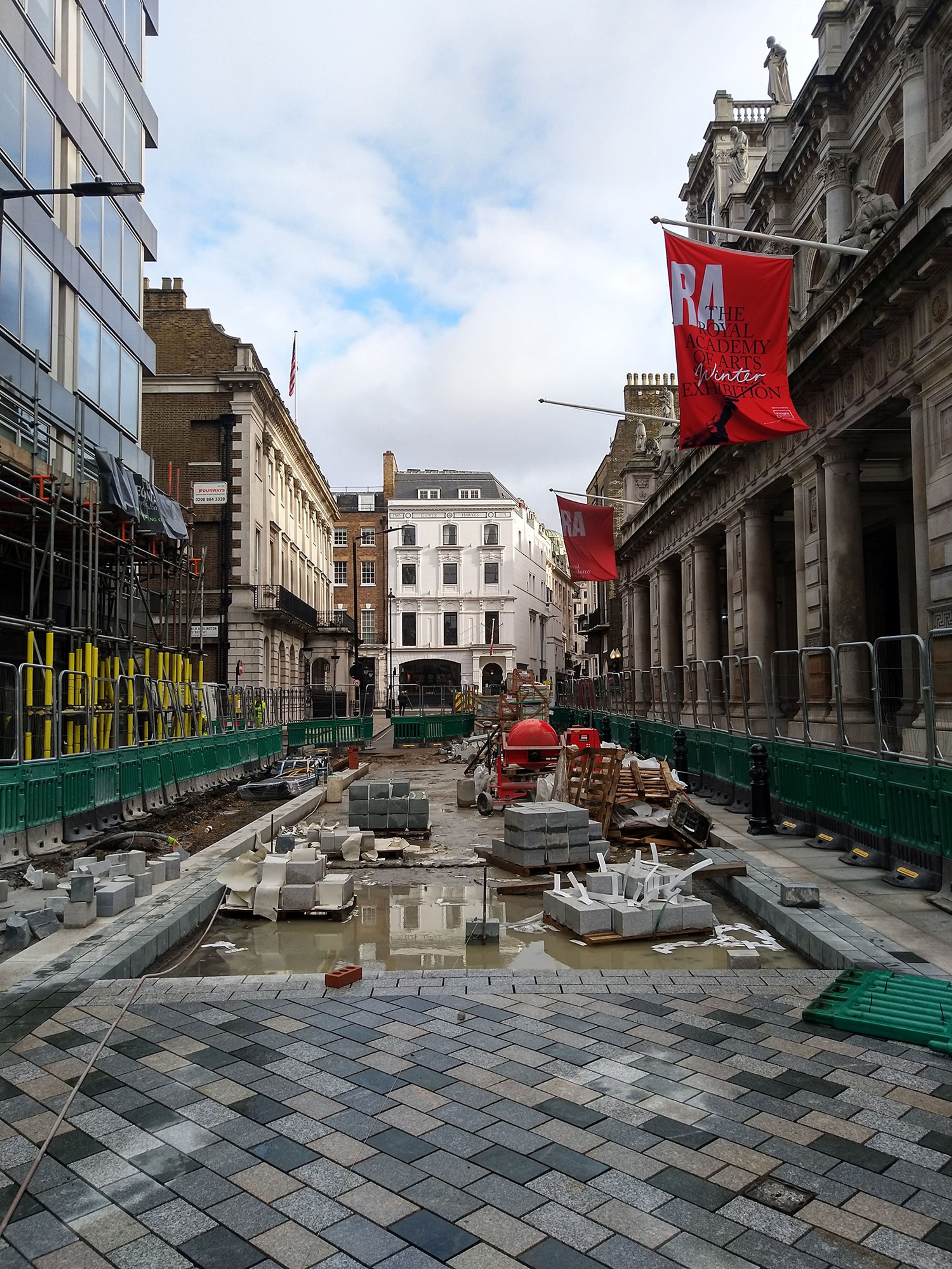 Construction site with bricks being laid down on an outside pathway.