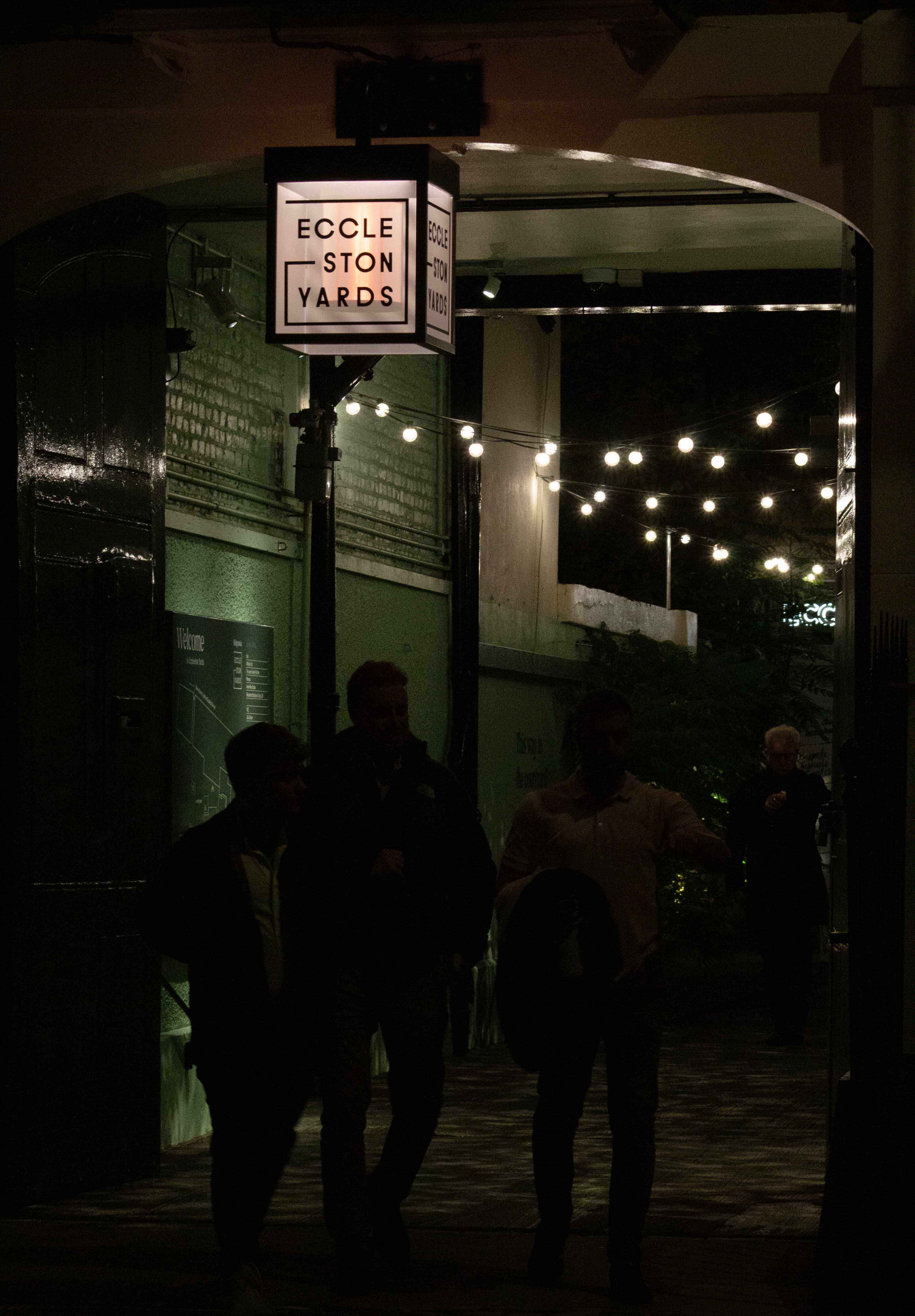 Photograph of the entrance of the courtyard at Eccleston Yards at night.