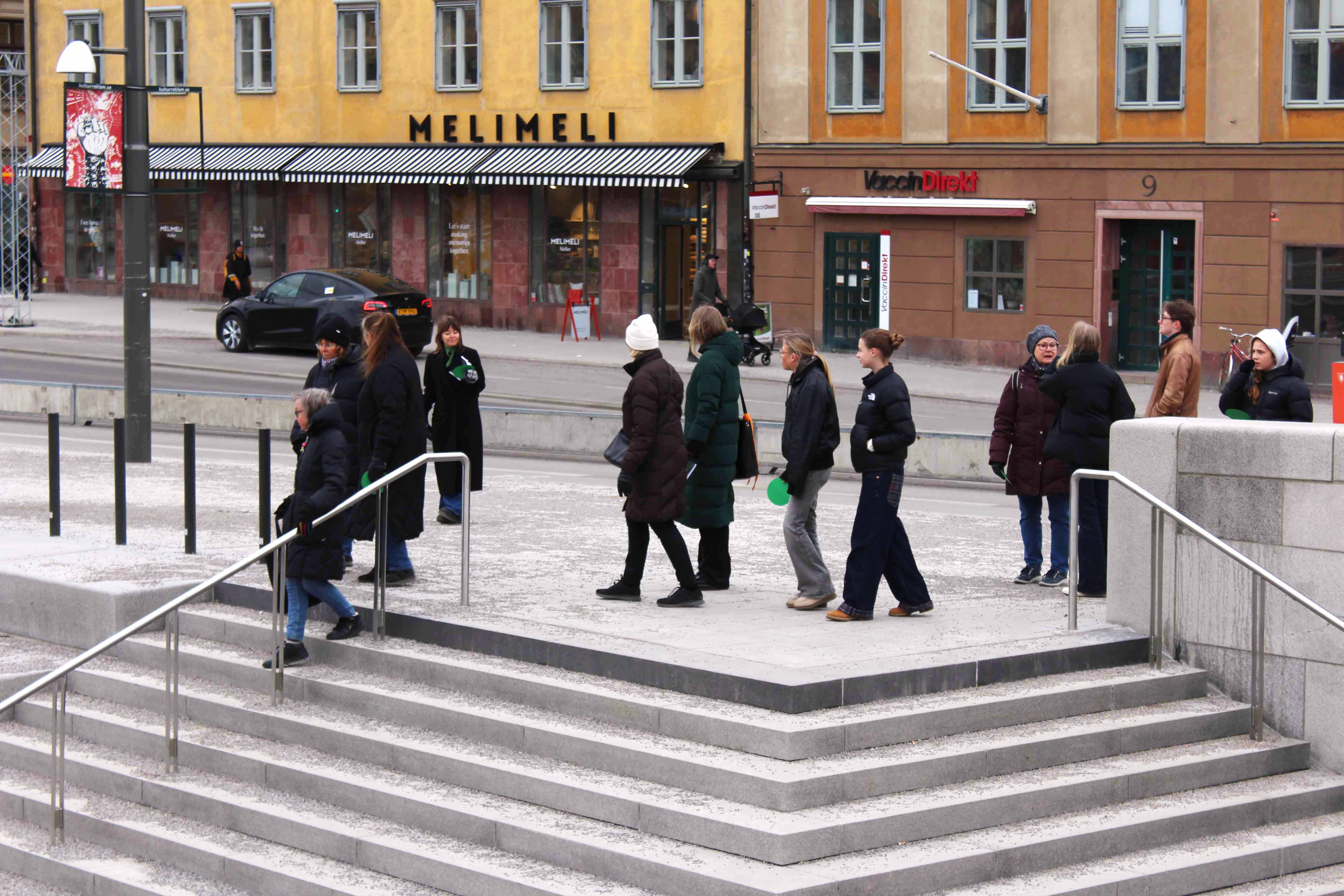 A group of people walking towards an outdoor staircase.