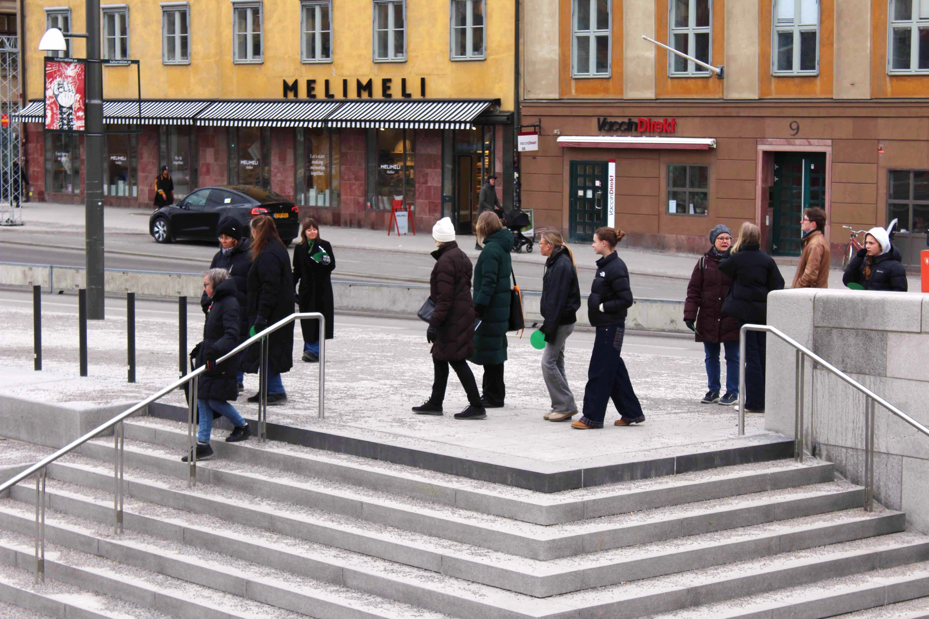 A group of people walking towards an outdoor staircase.