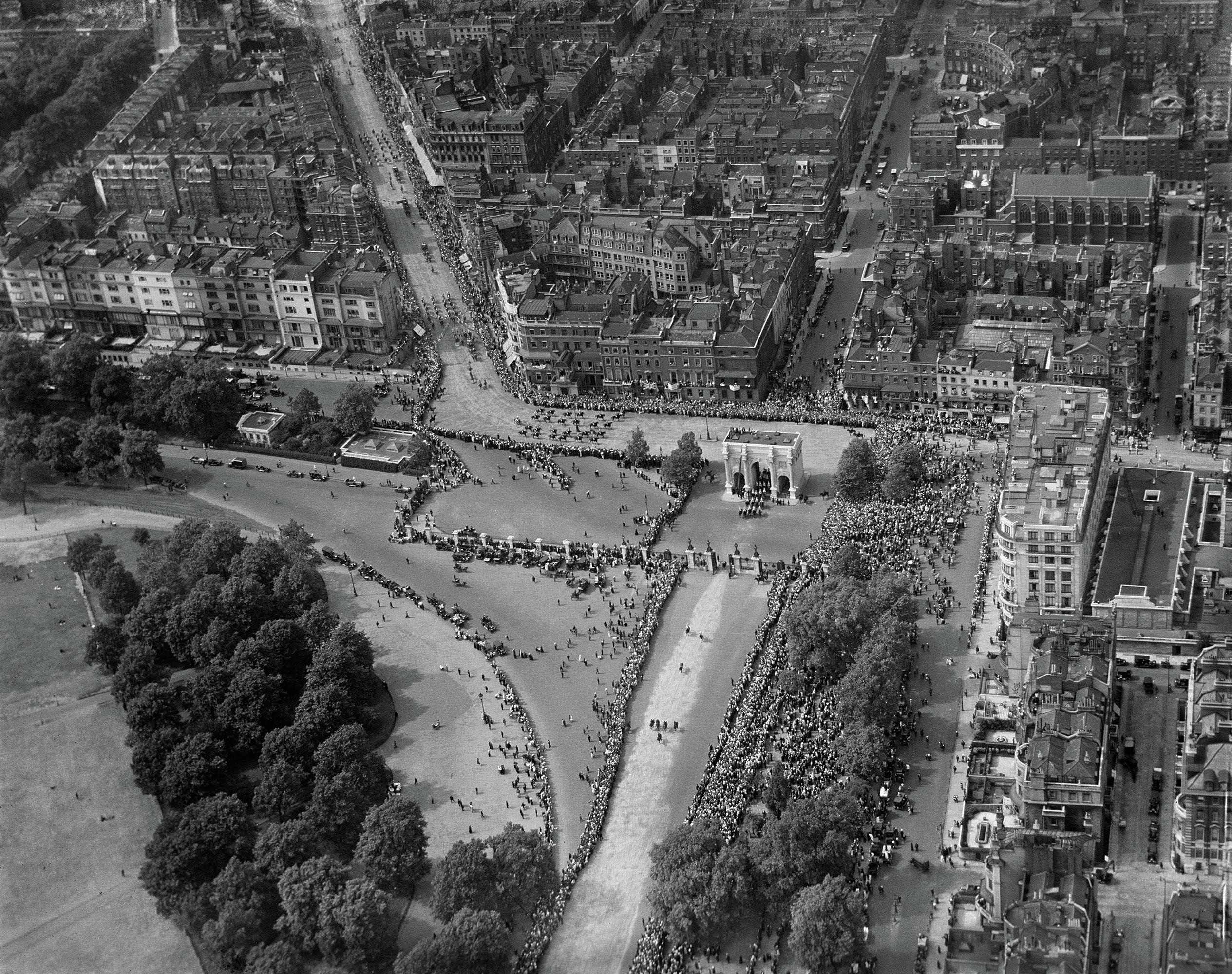 Areal black and white photograph of Marble Arch during a parade. 