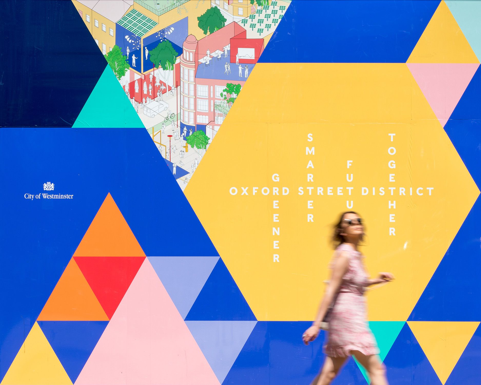 A person walks past a brightly coloured wall with geometric shapes.