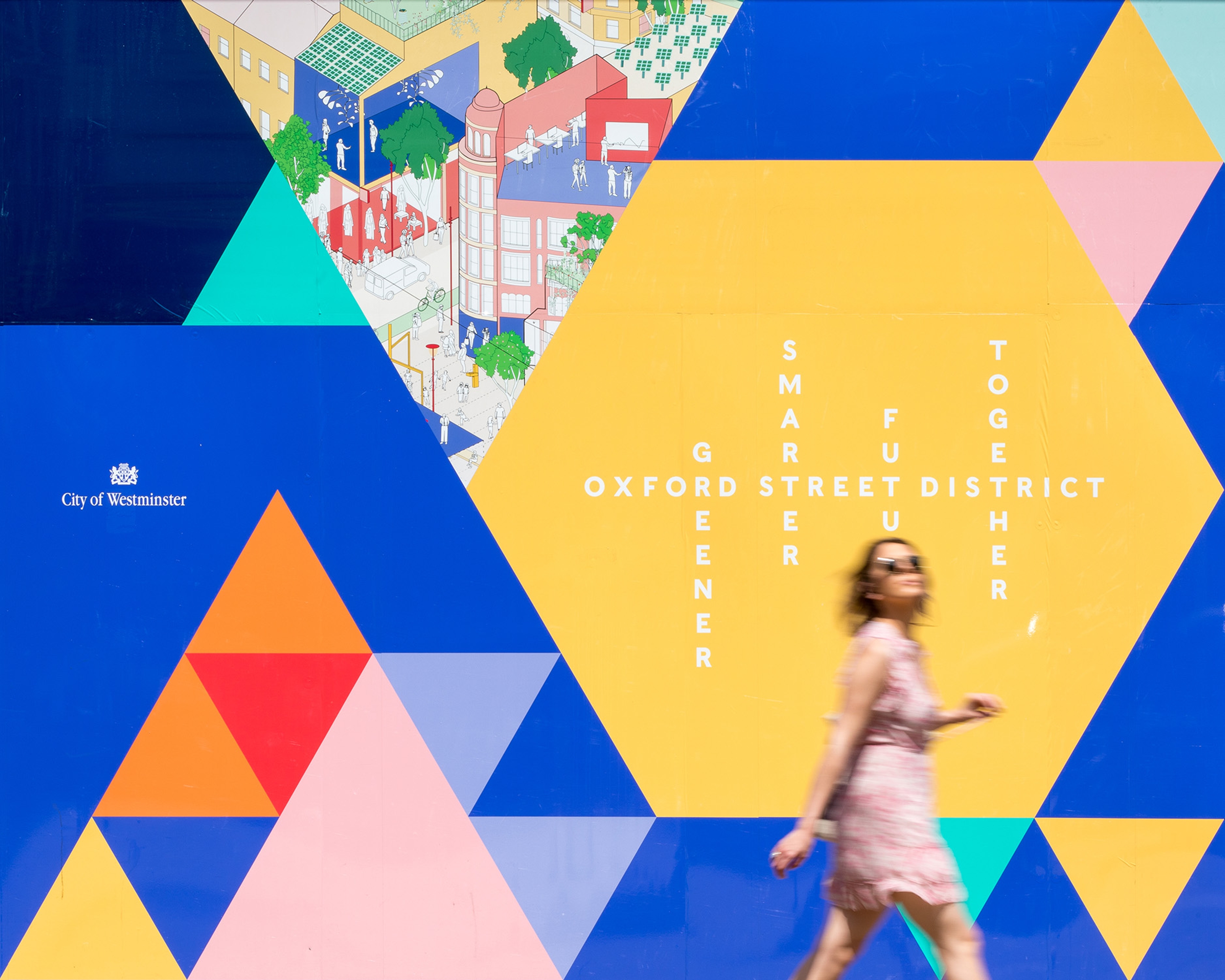 A person walks past a brightly coloured wall with geometric shapes.