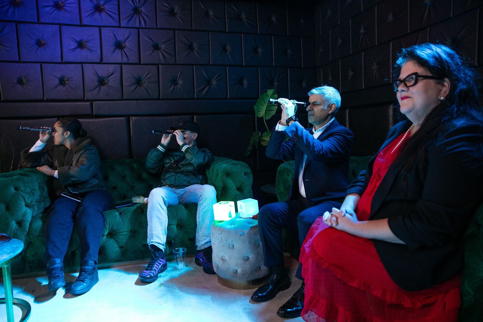 Four people, including Sadiq Khan, sit on sofas with three of them using telescopes.