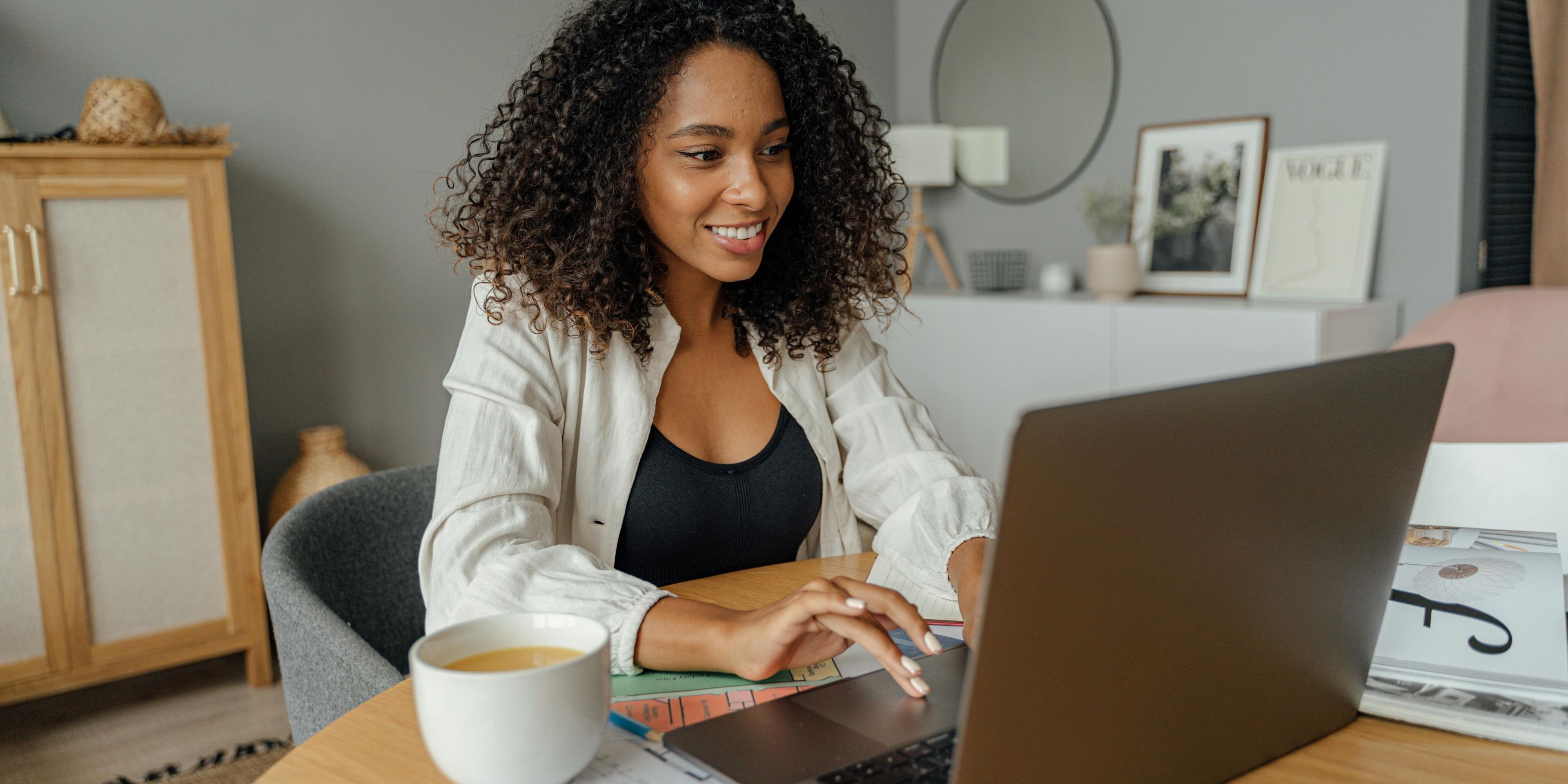 a woman is sitting at a table using a laptop computer .