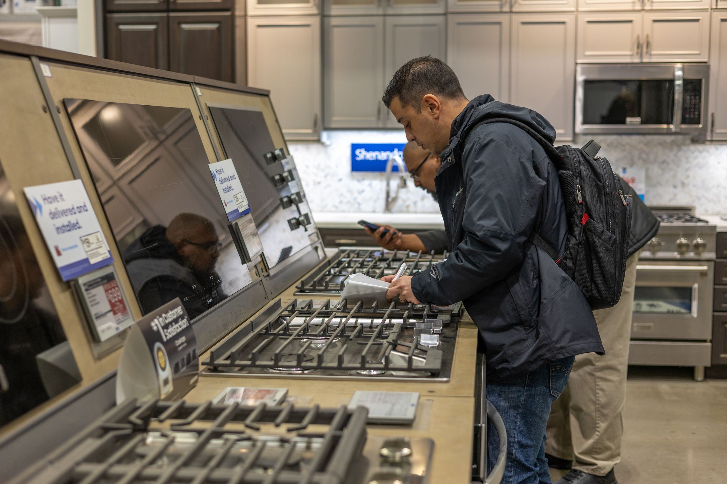 A retail associate showing a consumers a home appliance.