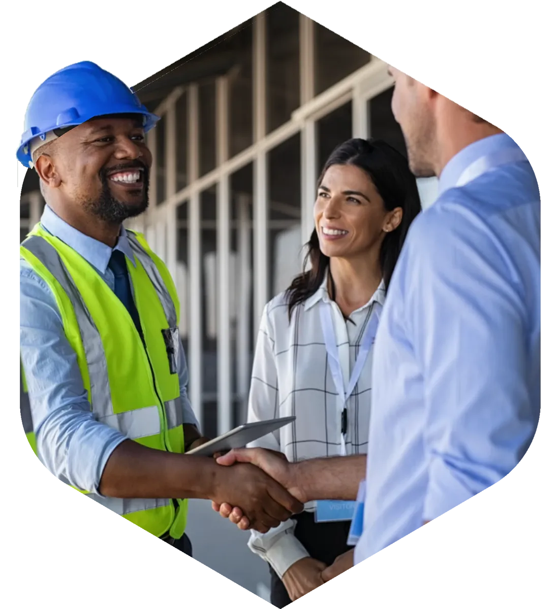 Construction worker and business associates smiling and shaking hands