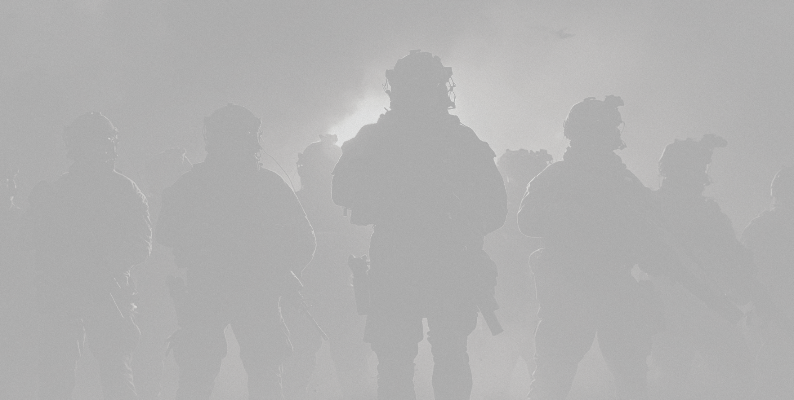 A squad in silhouette against a smoke-lit sky