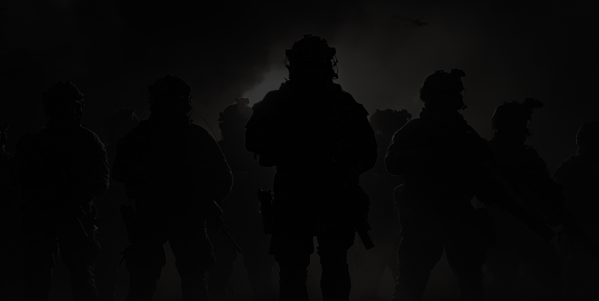 A squad in silhouette against a smoke-lit sky