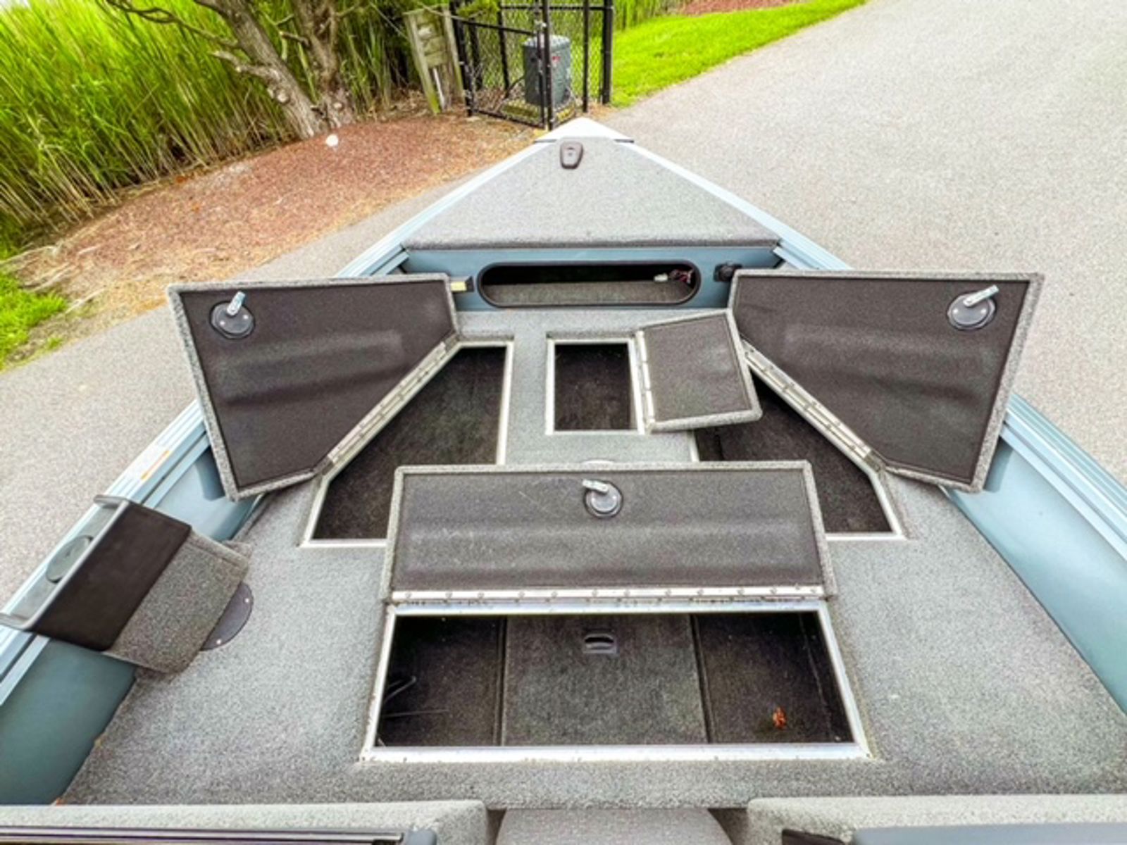 Bow of the Starcraft Storm 16 DC with the carpeted storage compartment lids open