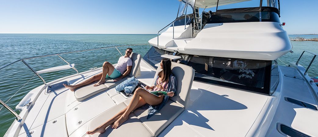 Guests relaxing on the Aquila 42 Yacht foredeck sun pad