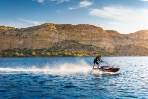 Kawasaki Jet Ski SX-R 160 rider standing on the watercraft, profile angle on the water