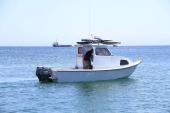 White Greenough 21 pilothouse with twin Yamaha outboards, side profile on open water