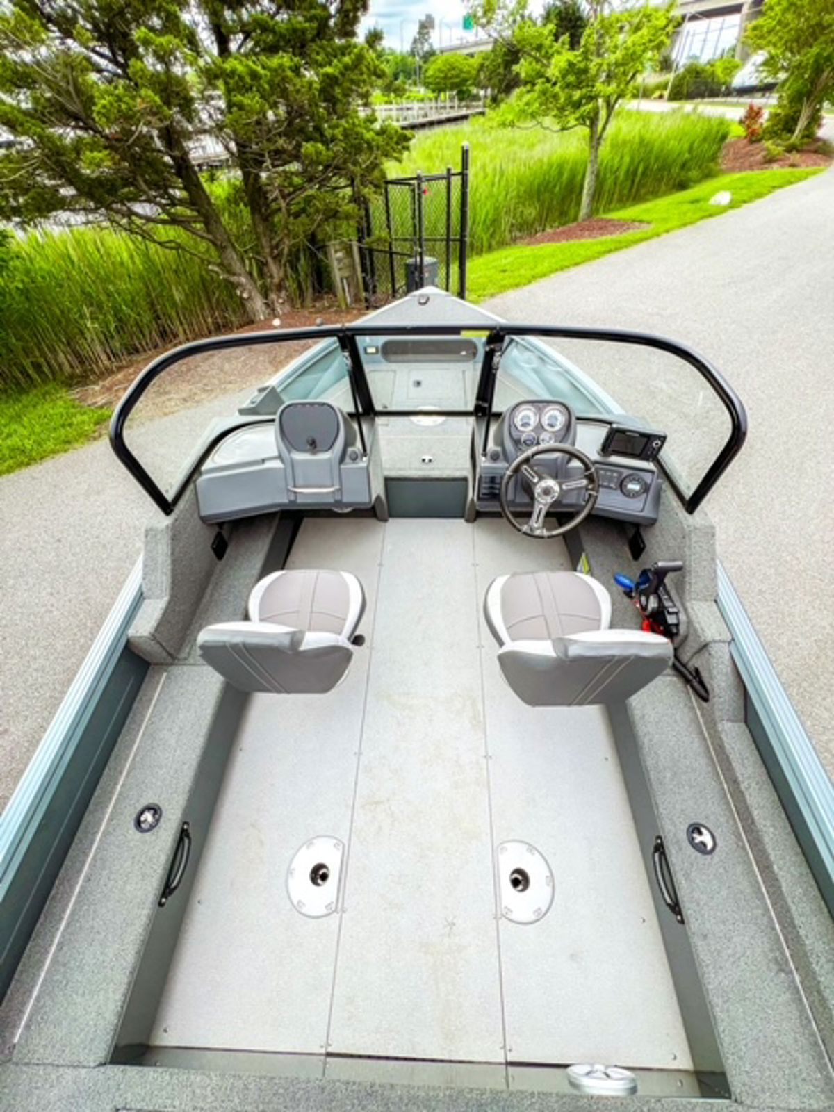 View down the open deck of the Starcraft Storm 16 DC from the stern, with two pedestal seats, dual console and wrap-around windshield