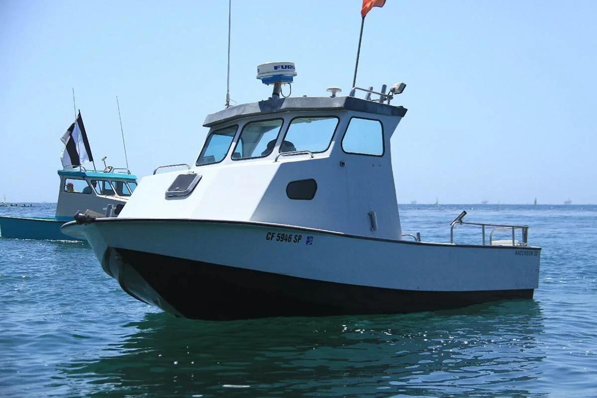 White Anderson 22 pilothouse workboat with radar arch at anchor on calm water