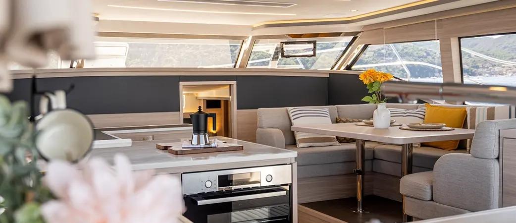 Aquila 46 Yacht salon with galley, U-shaped seating and panoramic windows