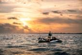 Rider standing on the Kawasaki Jet Ski Ultra 160LX-S Angler at sunset
