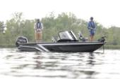 Black and grey Starcraft Storm fishing boat with two anglers casting, an outboard on the transom and trees along the bank