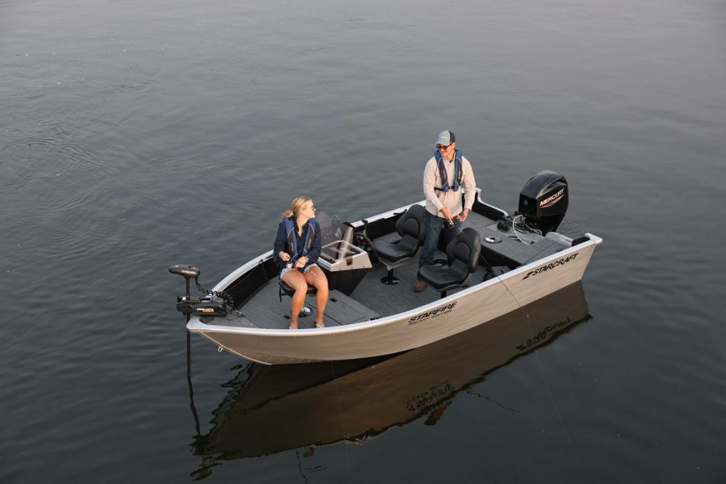 Aerial view of a grey Starcraft Storm aluminium fishing boat on dark water with two anglers seated on board and an outboard on the transom