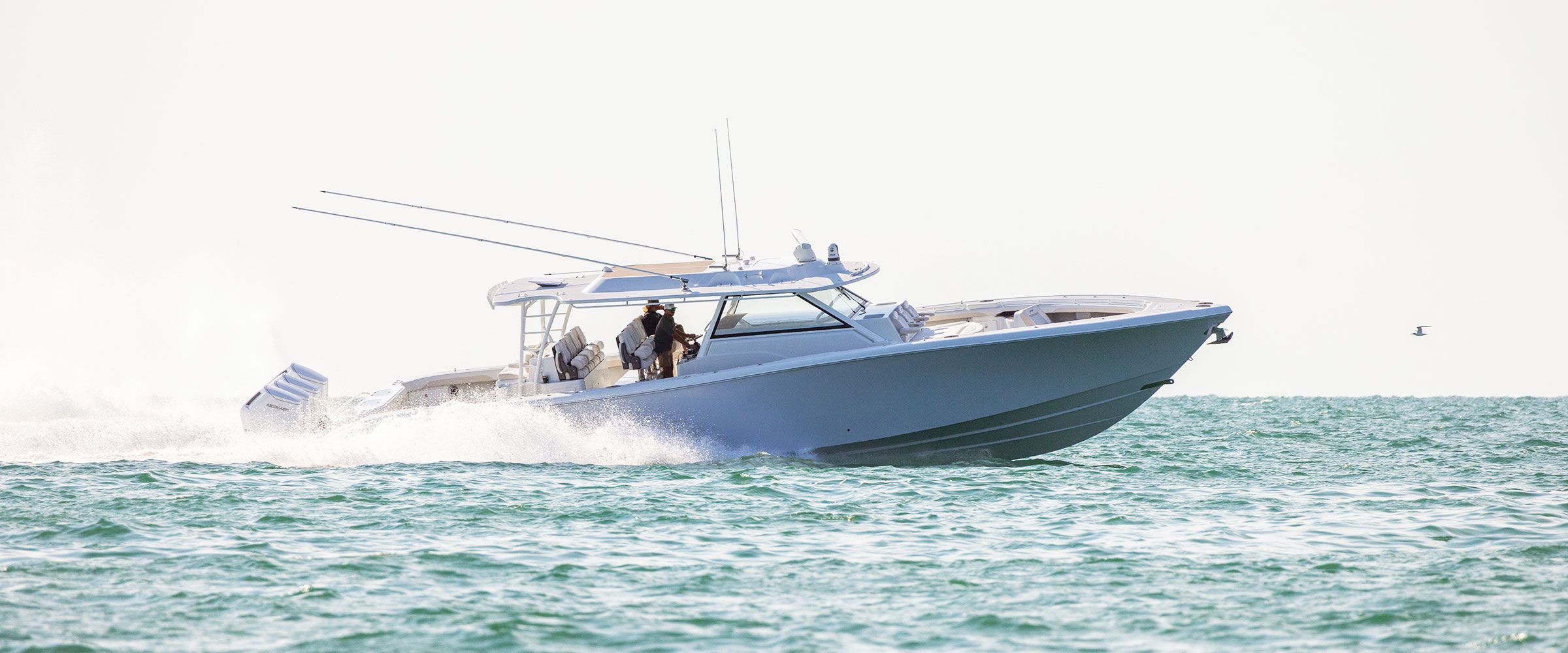 Yellowfin 54 Offshore running in bright sunlight, side view, with quad outboards