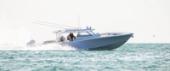 Yellowfin 54 Offshore running in bright sunlight, side view, with quad outboards