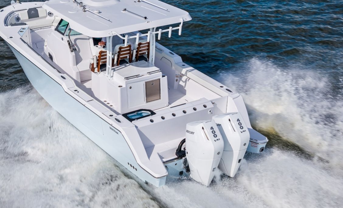 Bertram 34CC aerial view running at speed with twin Mercury outboards
