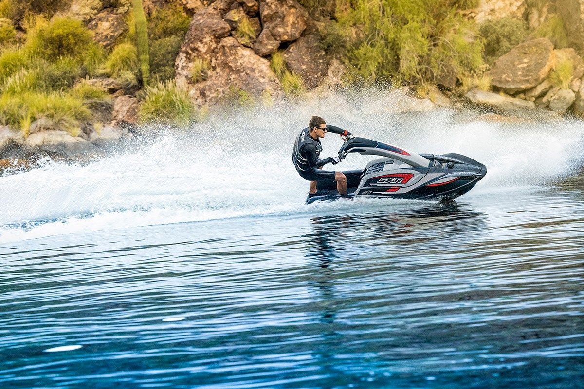 Kawasaki Jet Ski SX-R 160 rider standing on the watercraft, side angle on the water
