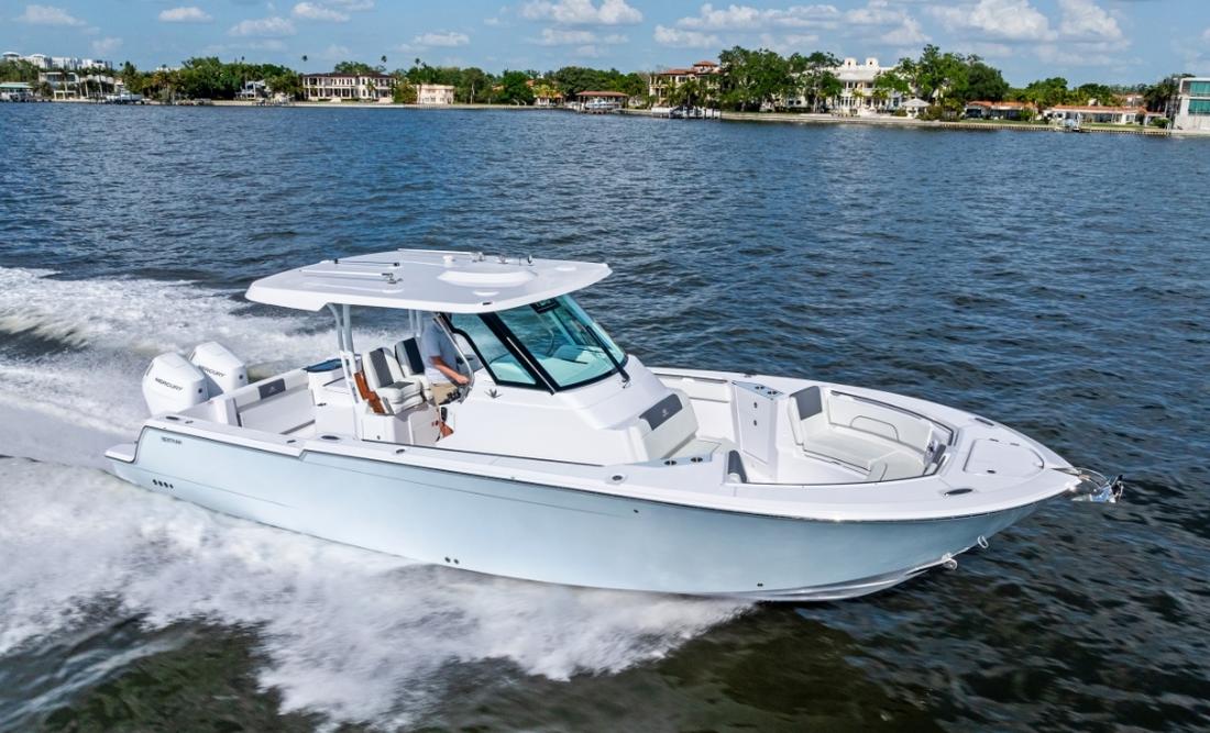 Bertram 34CC centre console running at speed along a palm-lined shore