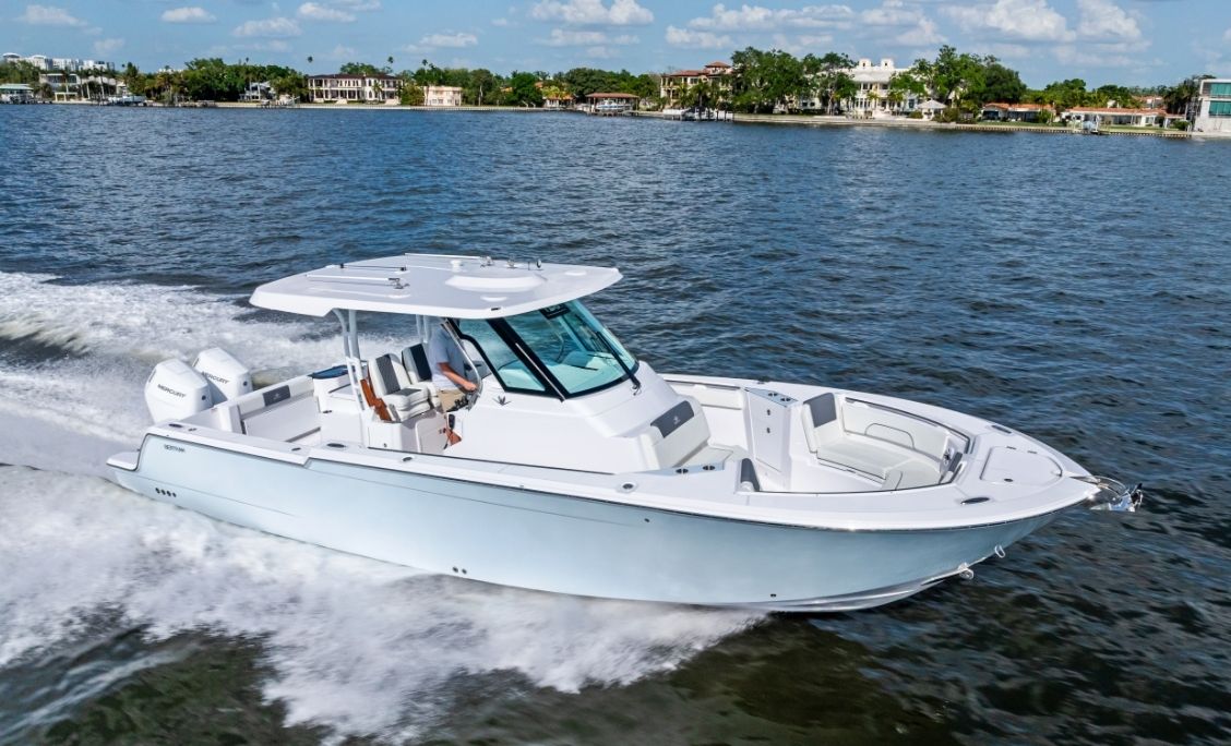 Bertram 34CC centre console running at speed along a palm-lined shore