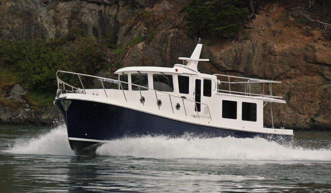 American Tug 395 cruising past a rocky shoreline