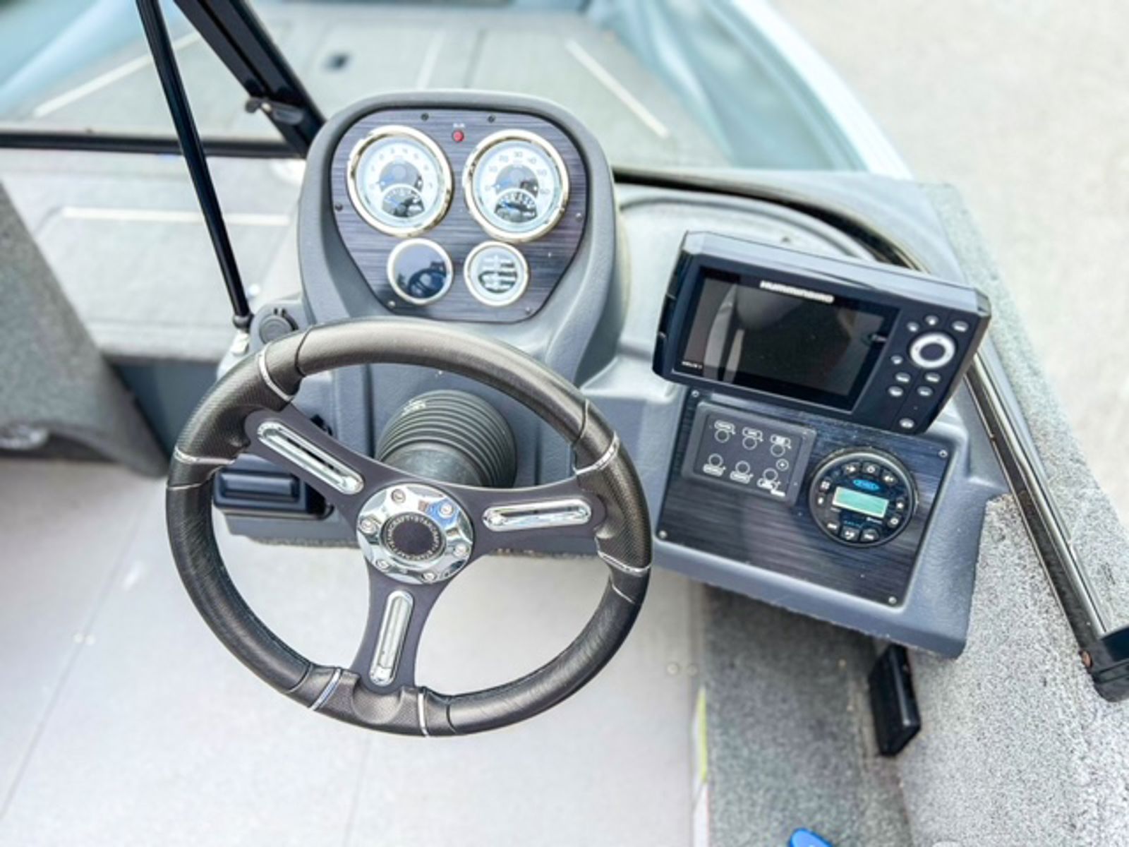 Helm of the Starcraft Storm 16 DC with steering wheel, gauges, fish finder display and switch panel