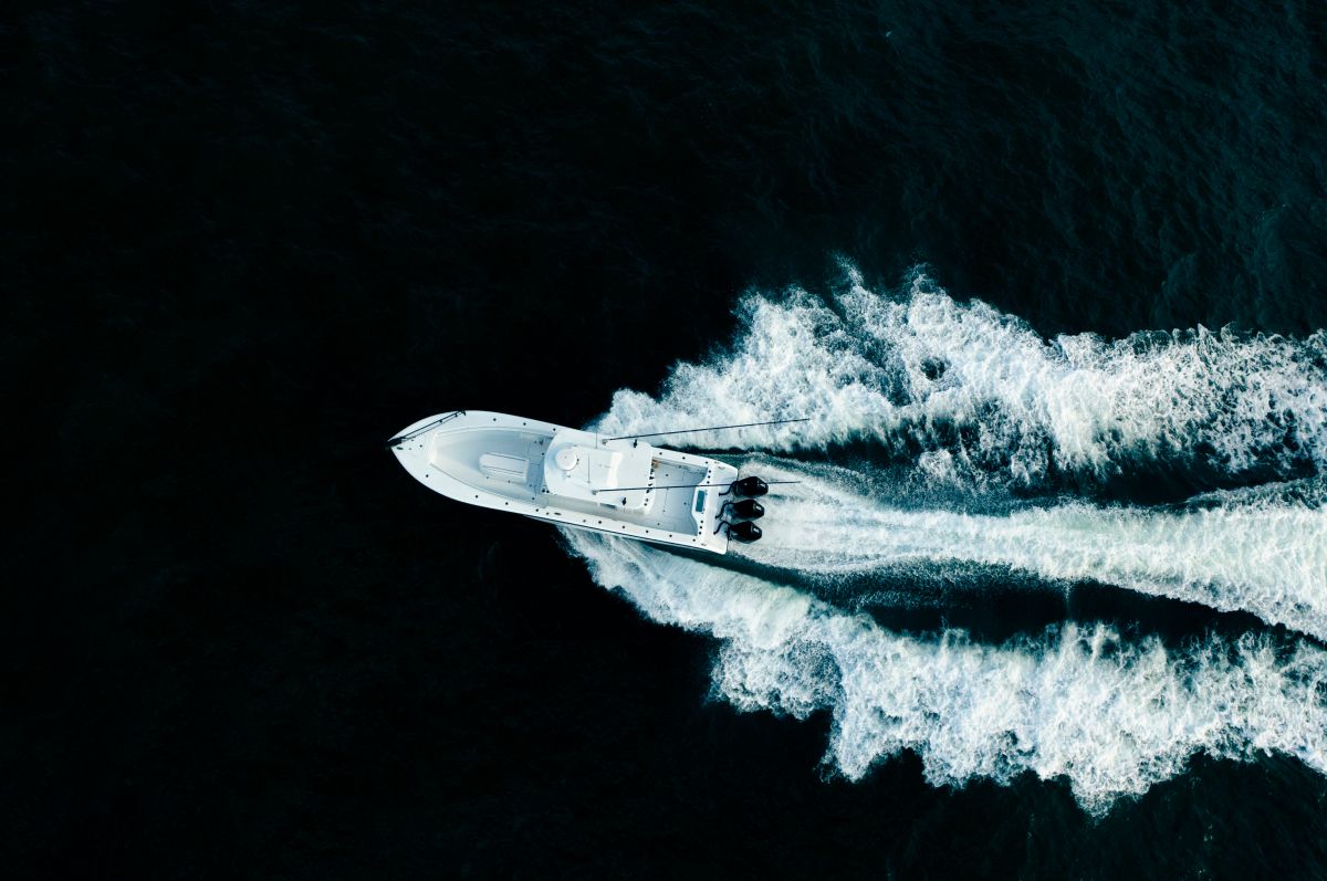 Aerial view of the Yellowfin 34 Offshore with a wide wake behind its triple outboards