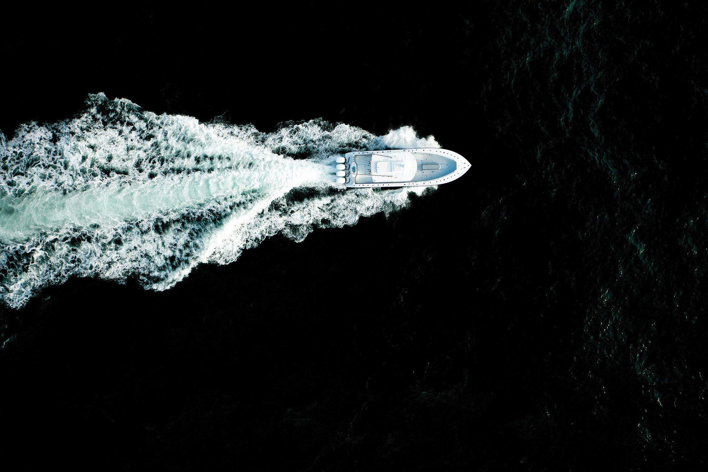 Aerial view of the Yellowfin 39 Offshore leaving a long wake on dark water