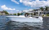 Bertram 34CC cruising past waterfront homes with guests aboard