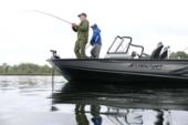 Anglers casting from the bow deck of a Starcraft STX 2050 with a windscreen and console, reflected in still water