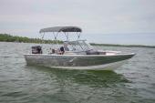 Crestliner 1600 Vision walk-through running with bimini top and outboard