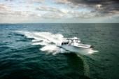 Yellowfin 34 Offshore heading out to sea at sunrise with rod holders on the hardtop