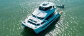Aerial view of the Aquila 54 Yacht at anchor in turquoise water with its tender
