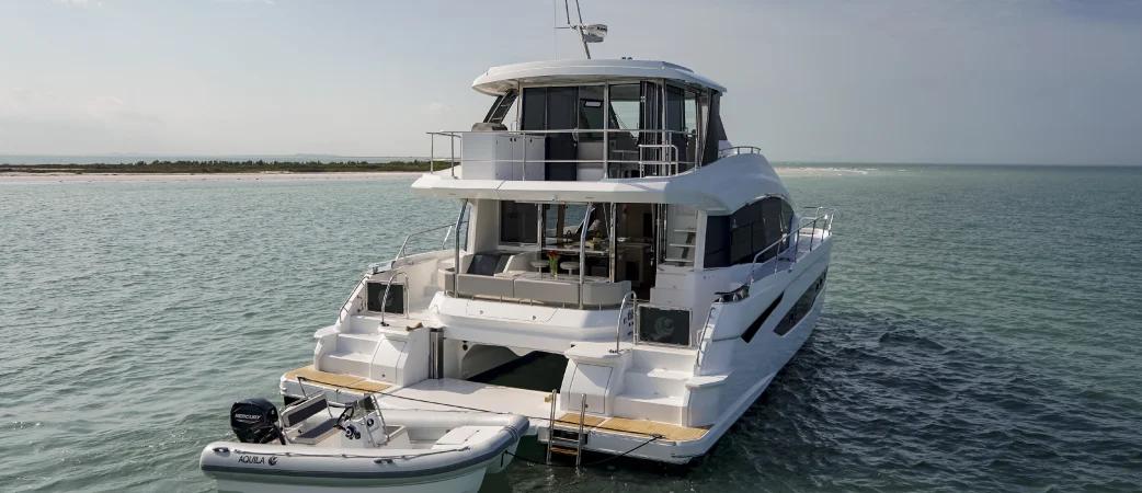 Aquila 54 Yacht from astern, showing transom steps, cockpit and flybridge