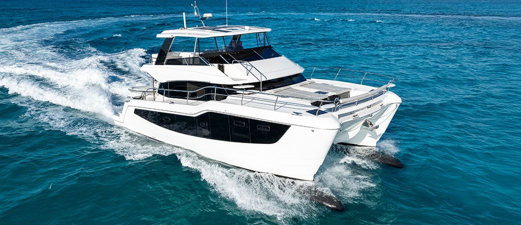 Aquila 50 Yacht explorer-style power catamaran running at speed in blue water